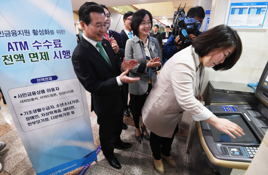 김용범 금융위원회 부위원장(왼쪽)이 2일 오전 서울 중구 우리은행 본점에서 초청 고객들과 ATM 기기를 시연하고 있다. 금융위는 새희망홀씨와 바꿔드림론, 징검다리론을 이용하는 사회 취약계층을 대상으로 현금자동입출금기(ATM) 수수료를 면제한다고 밝혔다.